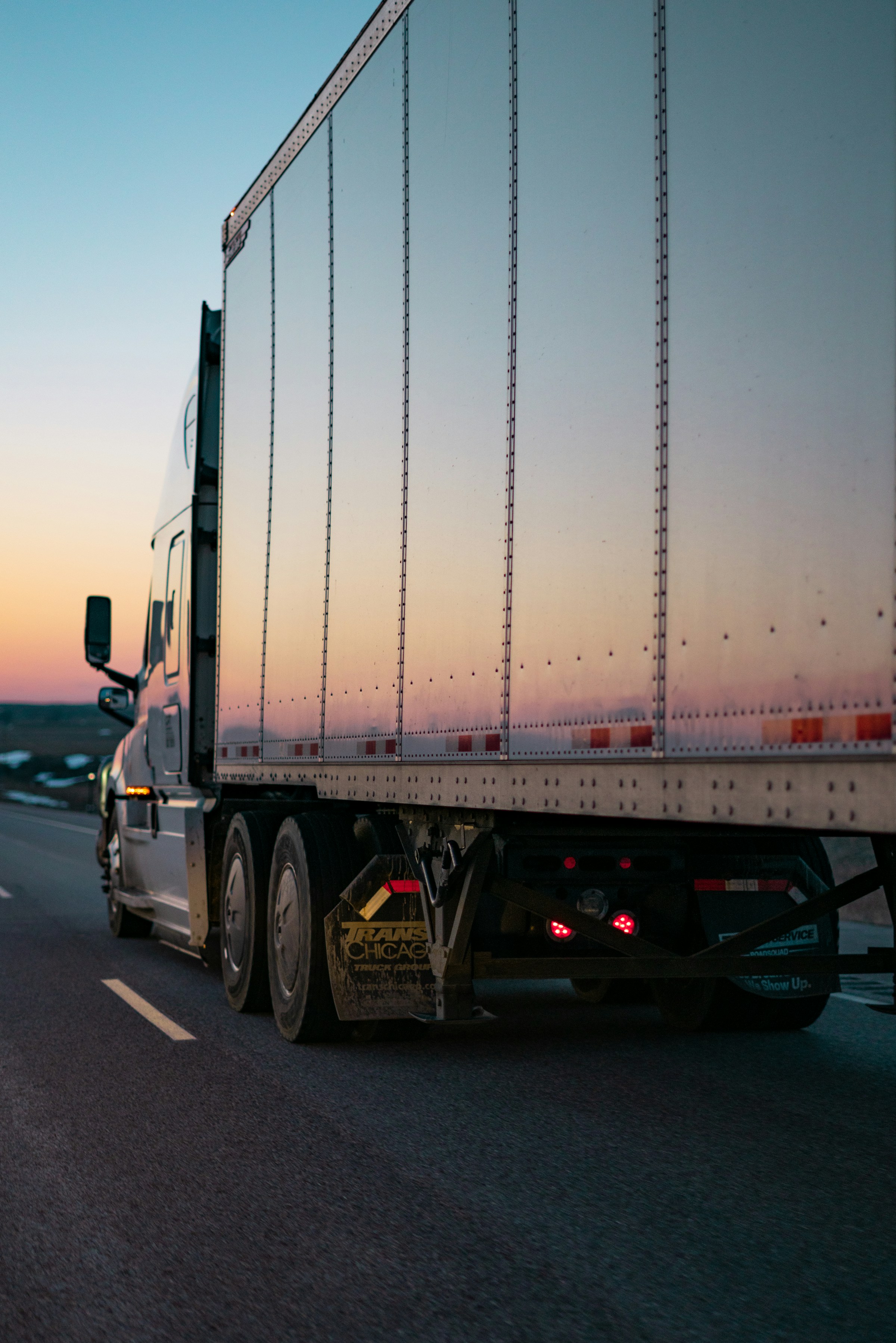 White semi truck traveling at sunset